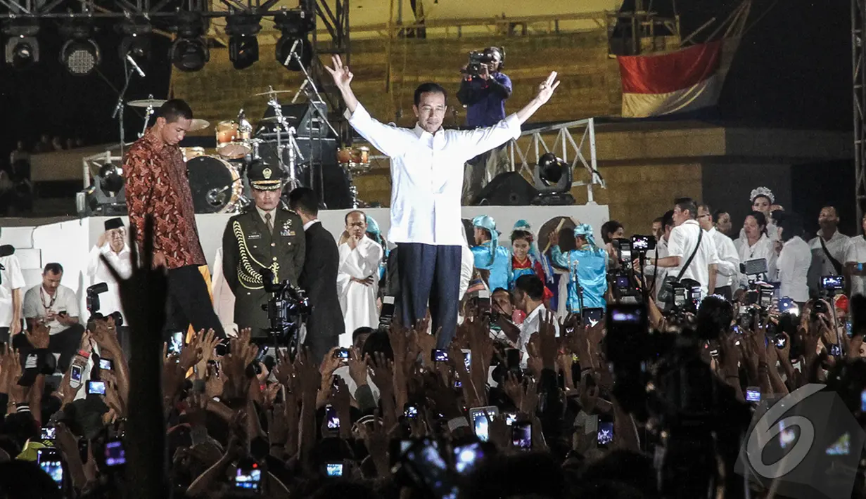Dalam acara itu, Jokowi berpidato dengan ciri khasnya, singkat, santai namun padat. Jokowi terlihat menyampaikan salam tiga jari, Jakarta Pusat, Senin (20/10/2014) (Liputan6.com/Faizal Fanani)