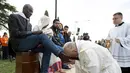 Paus Fransiskus mencium kaki imigran sebelum memimpin misa Kamis Putih, di sebuah lokasi penampungan di Castelnuovo, dekat Roma, Italia, Kamis (24/3/2016). (Reuters/ Osservatore Romano)