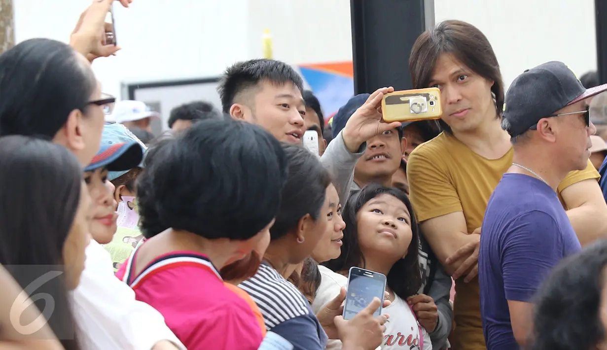 Once berpose bersama penggemarnya saat syuting video klip untuk Ahok di RPTRA Kalijodo, Jakarta, Kamis (5/1). Video klip ini dibuat sebagai bentuk dukungan untuk Ahok dan Djarot. (Liputan6.com/Herman Zakharia)