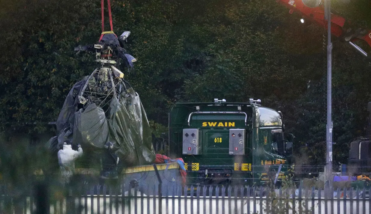 Crane mengevakuasi bangkai helikopter dari lokasi kecelakaan yang menewaskan pemilik Leicester City Vichai Srivaddhanaprabha di Leicester, Inggris, Kamis (1/11). Kondisi helikopter terlihat rusak parah dengan bekas terbakar api. (Aaron Chown/PA via AP)