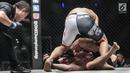 Dua petarung Indonesia Yohan Mulia Legowo (bawah) berusaha lepas dari teknik kunci Victorio Senduk (atas) pada laga One Championship di Jakarta, Sabtu (20/1). Pada laga tersebut Victorio Senduk menang atas Yohan Mulia. (Liputan6.com/Faizal Fanani)
