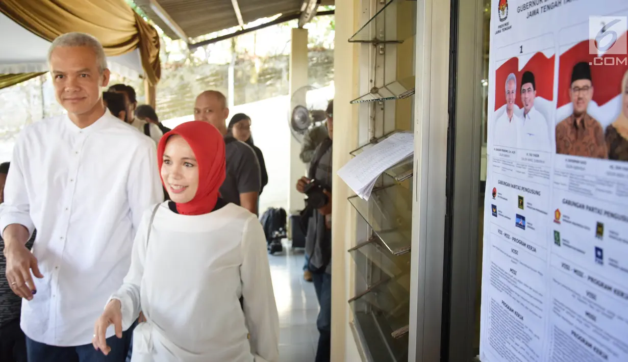 Calon Gubernur Jawa Tengah nomor urut 1, Ganjar Pranowo bersama istri, Siti Atiqoh tiba di TPS 02 Kelurahan Gajahmungkur, Kota Semarang, Rabu (27/6). Ganjar Pranowo bersama istri menyalurkan hak pilihnya di Pilkada Jawa Tengah. (Liputan6.com/Gholib)