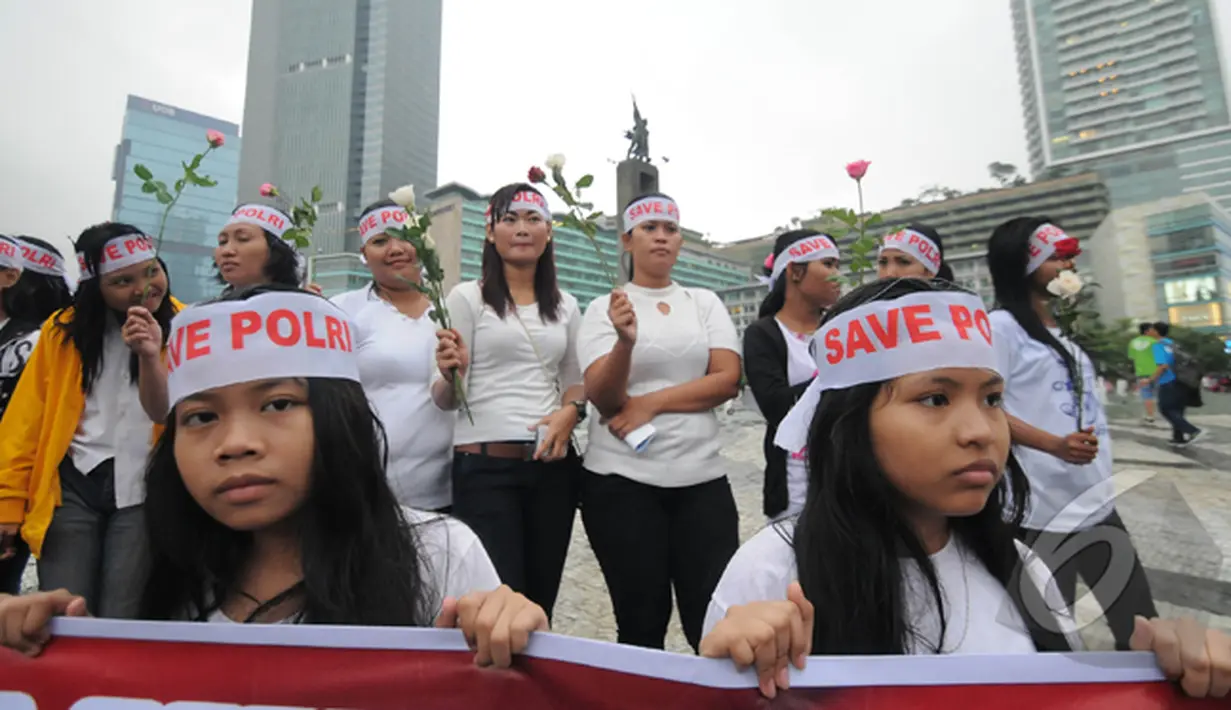 Sebagian besar peserta aksi ini mengenakan baju kaos putih dan mengenakan ikat kepala bertuliskan 'Save Polri', Bundaran HI, Jakarta, Minggu (1/2/2015). (Liputan6.com/Herman Zakharia)