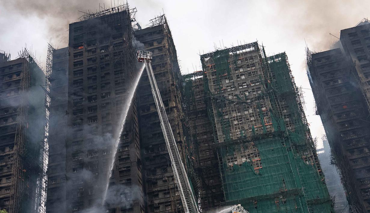 Kebakaran bermula terjadi pada sebuah kompleks residen besar di distrik Tai Po, Hong Kong, Wang Fuk Court, Pada Rabu (26/11/2025) sekitar pukul pukul 14.51 waktu setempat. Tampak dalam foto, petugas pemadam kebakaran berupaya memadamkan kebakaran yang terjadi di Wang Fuk Court, sebuah kompleks perumahan di distrik Tai Po, Wilayah Baru Hong Kong, Kamis 27 November 2025. (AP Photo/Chan Long Hei)