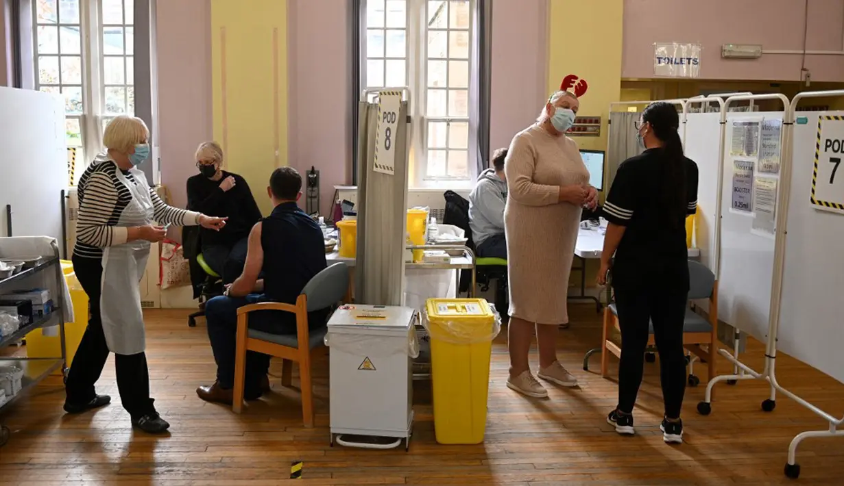 Orang-orang menunggu untuk menerima dosis vaksin COVID-19 Moderna di Rumah Sakit Babington, Belper, Inggris, 16 Desember 2021. Inggris melaporkan rekor COVID-19 baru mencapai 88.376 kasus dalam 24 jam pada 16 Desember 2021, pecahkan rekor sehari sebelumnya yaitu 78.610 kasus. (Oli SCARFF/AFP)