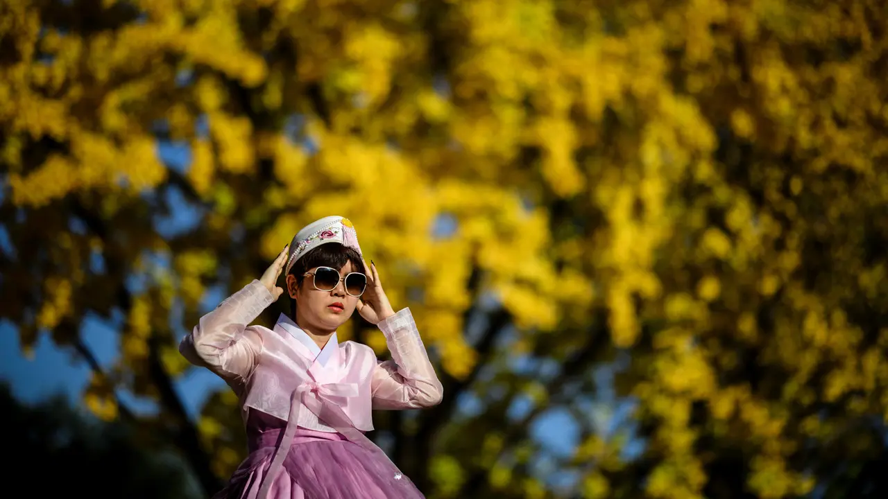 Wanita mengeakan hanbok. (ANTHONY WALLACE / AFP)