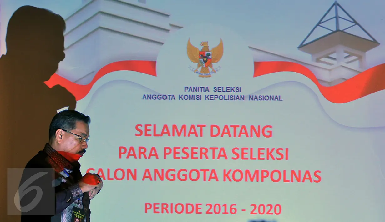 Seorang pria berjalan melewati layar monitor di sebuah hotel di Jakarta, Kamis (10/3). Komisi Kepolisian Nasional (Kompolnas) mengadakan ujian tahap kedua kepada 81 calon anggota yang lolos administrasi pada tahap pertama. (Liputan6.com/Johan Tallo)