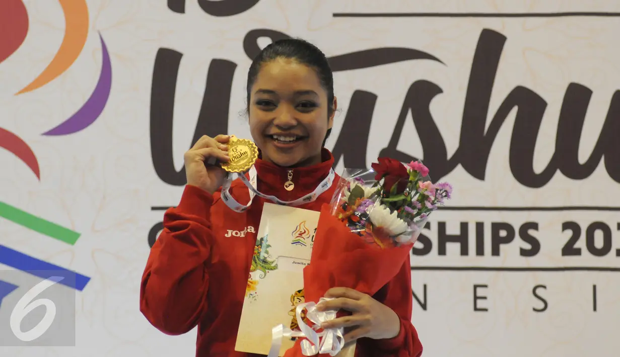 Atlet Wushu Indonesia, Juwita Niza WA tersenyum usai menerima medali emas kelas Taulo Womens Nangun Kejuaraan DuniaWushu ke-13 di IstoraSenayan Jakarta, Selasa (17/11/2015). Juwita meraih emas dengan total poin 9.58. (Liputan6.com/Helmi Fithriansyah)