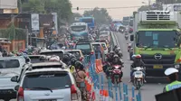 Arus lalu lintas dari Jalur Pantura Cikampek mengarah Jakarta terlihat macet di jalan Jendral Sudirman,Cikampek,  Jawa Barat, Sabtu (7/1). (Liputan6.com/Helmi Afandi)