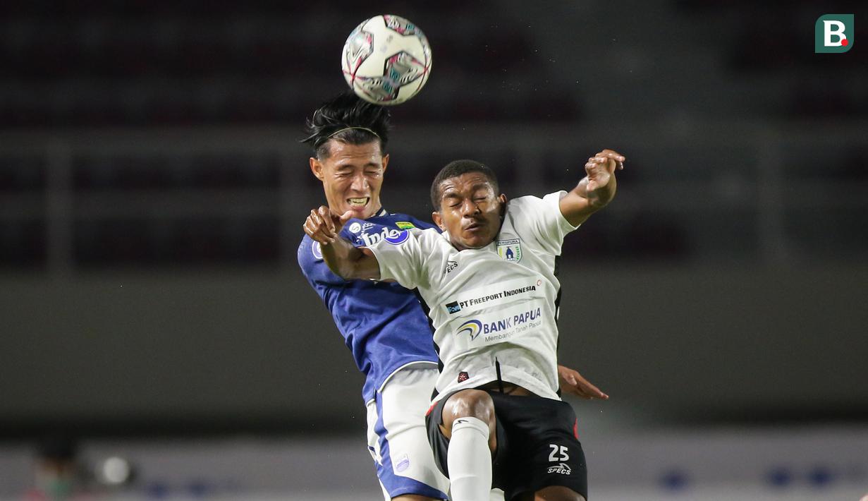 Pemain Persib Bandung, Henhen Herdiana (kiri) berduel udara dengan pemain Persipura Jayapura, Juscak Joshua Marthen Isir dalam laga pekan ke-10 BRI Liga 1 2021/2022 di Stadion Manahan, Solo, Sabtu (30/10/2021). (Bola.com/Bagaskara Lazuardi)
