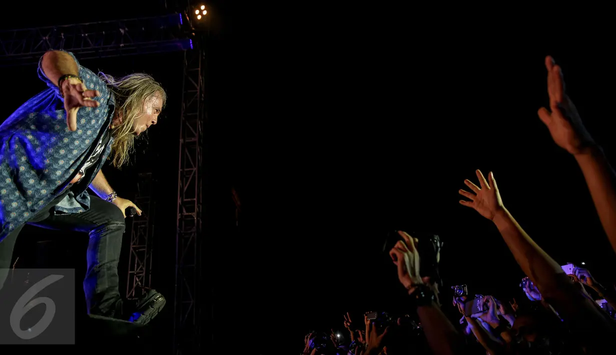 Interaksi Vokalis Helloween, Andi Deris dengan penonton saat aksi panggung di Senayan, Jakarta, Kamis (22/10/2015). Penampilan Helloween di Jakarta merupakan bagian dari tur Helloween My God-Given Right Tour 2015. (Liputan6.com/Faizal Fanani)
