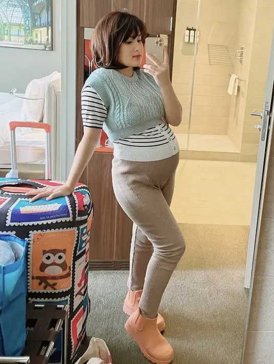 <p>Ketika hamil, Rosiana pun sempat berlibur ke Eropa. Dengan baby bumpnya, ia terlihat mengenakan inner &nbsp;motif garis diatas vest warna mint. Dipadukan celana cokelat dan sepatu boots orangenya. @rsn.dw</p>