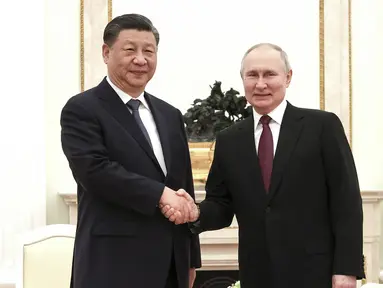 Dalam foto selebaran yang dirilis oleh Kantor Pers Kepresidenan Rusia ini memperlihatkan Presiden Rusia Vladimir Putin (kanan) dan Presiden Tiongkok Xi Jinping berjabat tangan sebelum pembicaraan mereka di Kremlin di Moskow, Senin (20/3/2023). (Russian Presidential Press Office via AP)