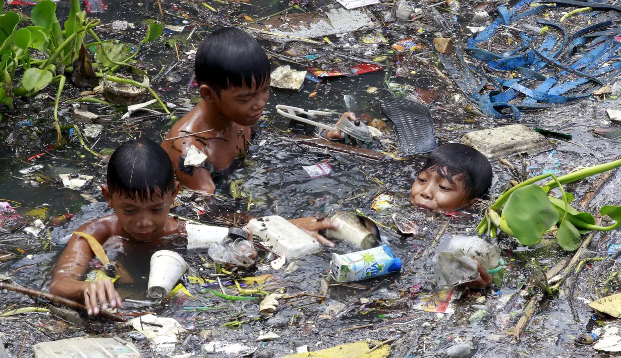 Sejumlah anak memilah sampah yang terapung untuk di jadikan bahan daur ulang di sebuah sungai yang tercemar di kota navotas, Manila, Kamis (2/7/2015). Daur ulang bertujuan untuk mengurangi tingkat pencemaran sungai. (REUTERS/Romeo Ranoco)