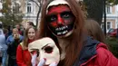 Seorang perempuan berpose dengan dandanan menyerupai zombie ketika berpartisipasi dalam 'Zombie Walk' di pusat Kota Kiev, Ukraina, 26 Oktober 2019. Menjelang perayaan Halloween pada 31 Oktober mendatang, warga di beberapa belahan dunia sudah mulai melakukan acara bertema horor. (AP/Efrem Lukatsky)