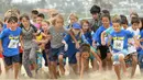 Sejumlah anak saat berpartisipasi dalam 'Tot Trot' selama Nautica Malibu Triathlon di Pantai Zuma di Malibu, California (14/9). (Noel Vasquez / Getty Images untuk Nautica / AFP)