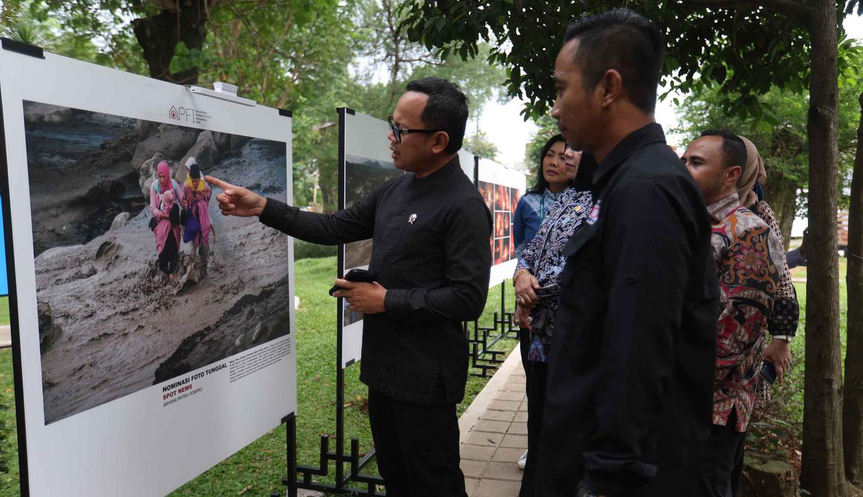 APFI 2026 hadir bukan sekadar seremoni penghargaan, tetapi juga menjadi simbol semangat bertahan para pewarta foto dalam menjaga kualitas jurnalisme visual. Tampak dalam foto, Wakil Menteri Dalam Negeri (Wamendagri), Bima Arya Sugiarto (kiri) didampingi Ketua Pewarta Foto Indonesia (PFI) Nasional, Dwi Pambudo melihat foto-foto pemenang ajang Anugerah Pewarta Foto Indonesia 2026 di halaman Auditorium Sekretariat Daerah Kabupaten Bogor, Jawa Barat, Jumat (8/5/2026). (Kapanlagi.com/Budy Santoso)