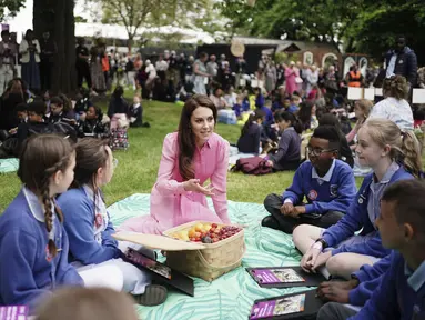 Kate Middleton berbicara dengan murid-murid dari sekolah yang mengambil bagian dalam Piknik Anak pertama di RHS Chelsea Flower Show, di Royal Hospital Chelsea, London, Senin (22/5/2023). (Jordan Pettitt/Pool via AP)