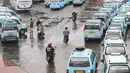 Pengendara sepeda motor melintasi jalur angkutan umum di Terminal Kampung Melayu, Jakarta, Rabu (6/2). Meskipun terdapat larangan melintas bagi pemotor, namun masih ada sejumlah pengendara nekat menerobos masuk terminal. (Liputan6.com/Immanuel Antonius)