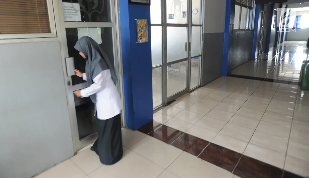 Guru mengunci pintu salah satu ruangan di Mts Annajah, Petukangan, Jakarta Selatan, Senin (5/8/2019). Masih padamnya listrik di sejumlah kawasan Jakarta membuat kegiatan belajar mengajar terganggu hingga memaksa pihak sekolah memulangkan siswa lebih awal. (merdeka.com/Arie Basuki)