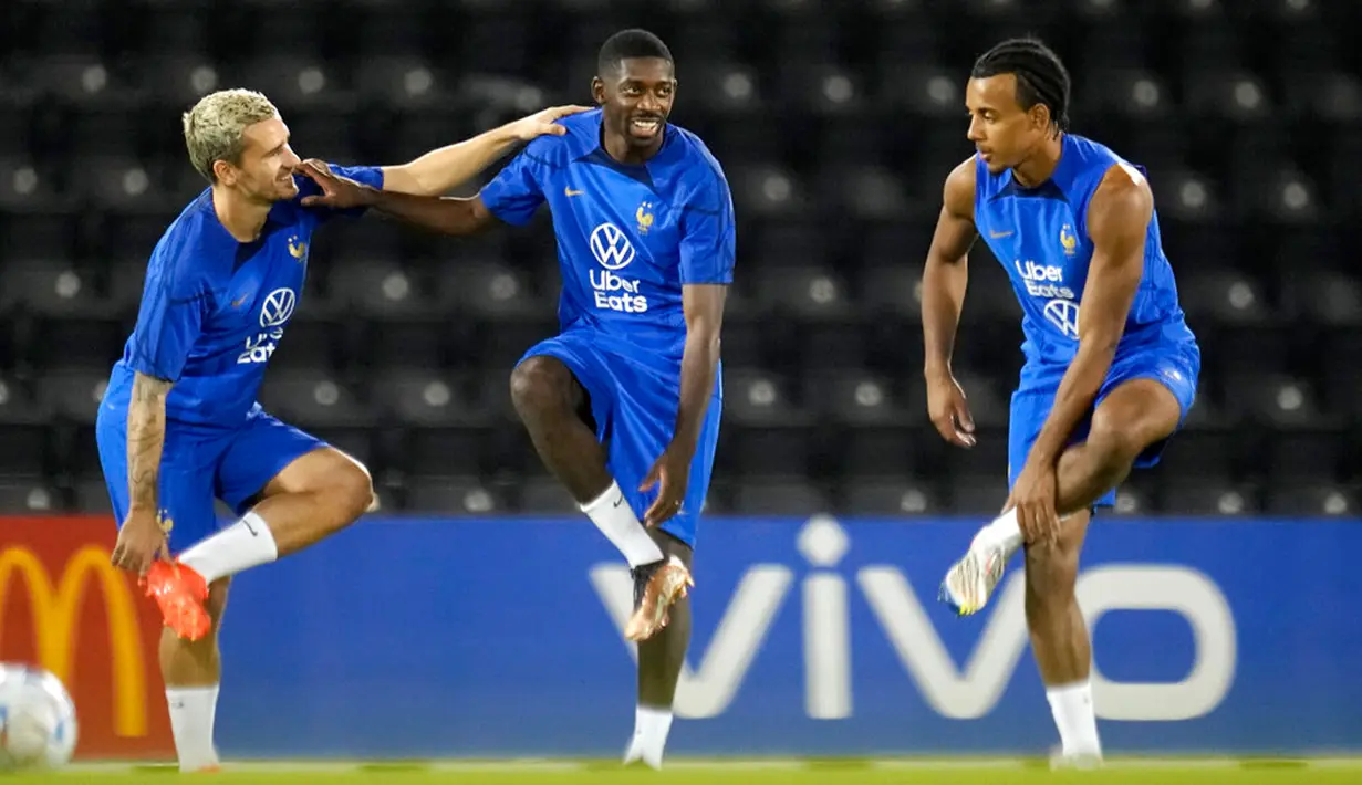 Pemain Prancis Ousmane Dembele (tengah) melakukan peregangan dengan Jules Kounde (kanan) dan Antoine Griezmann saat sesi latihan di Stadion Jassim Bin Hamad, Doha, Qatar, 28 November 2022. Prancis akan melawan Tunisia di Piala Dunia pada 30 November 2022. (AP Photo/Christophe Ena)