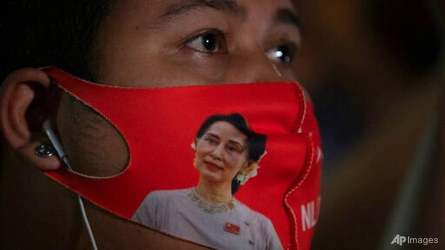 Seorang warga negara Myanmar yang tinggal di Thailand mengenakan masker wajah dengan gambar pemimpin Myanmar Aung San Suu Kyi selama protes di depan Kedutaan Besar Myanmar di Bangkok, Thailand, pada 4 Februari 2021.