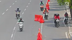 Pengendara sepeda motor melintasi jalur sepeda di Jalan MH Thamrin, Jakarta, Selasa (24/9/2019). Jalur sepeda yang mulai diuji coba pada 20 September 2019 lalu tersebut belum steril dari kendaraan bermotor. (Liputan6.com/Herman Zakharia)