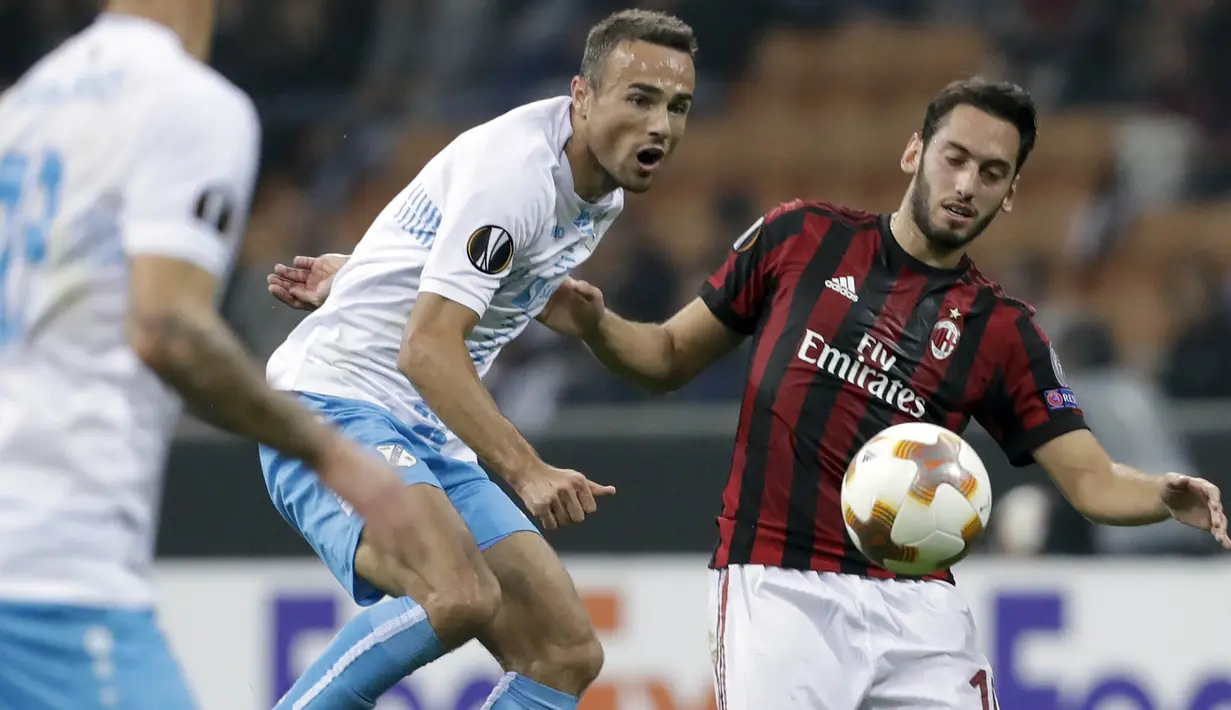 Gelandang AC Milan, Hakan Calhanoglu, duel udara dengan  gelandang Rijeka, Zoran Kvrzic, pada laga Liga Europa di Stadion San Siro, Milan, Kamis (28/9/2017). AC Milan menang 3-2 atas  Rijeka. (AP/Luca Bruno)