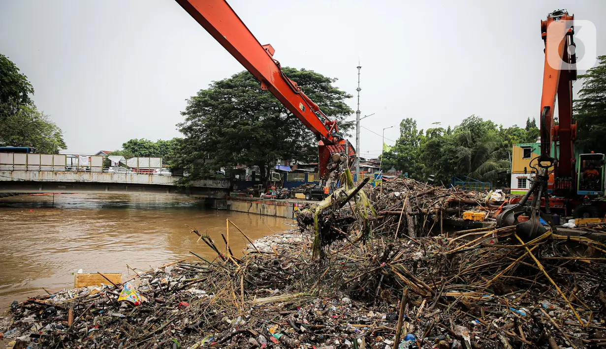 Petugas Dinas Kebersihan DKI Jakarta menggunakan alat berat untuk membersihkan sampah di Pintu Air Manggarai, Jakarta, Senin (10/10/2022). Hujan lebat yang mengguyur wilayah Bogor dan sekitarnya menyebabkan debit air Sungai Ciliwung meningkat dan menghanyutkan sampah ke Pintu Air Manggarai. (Liputan6.com/Faizal Fanani)