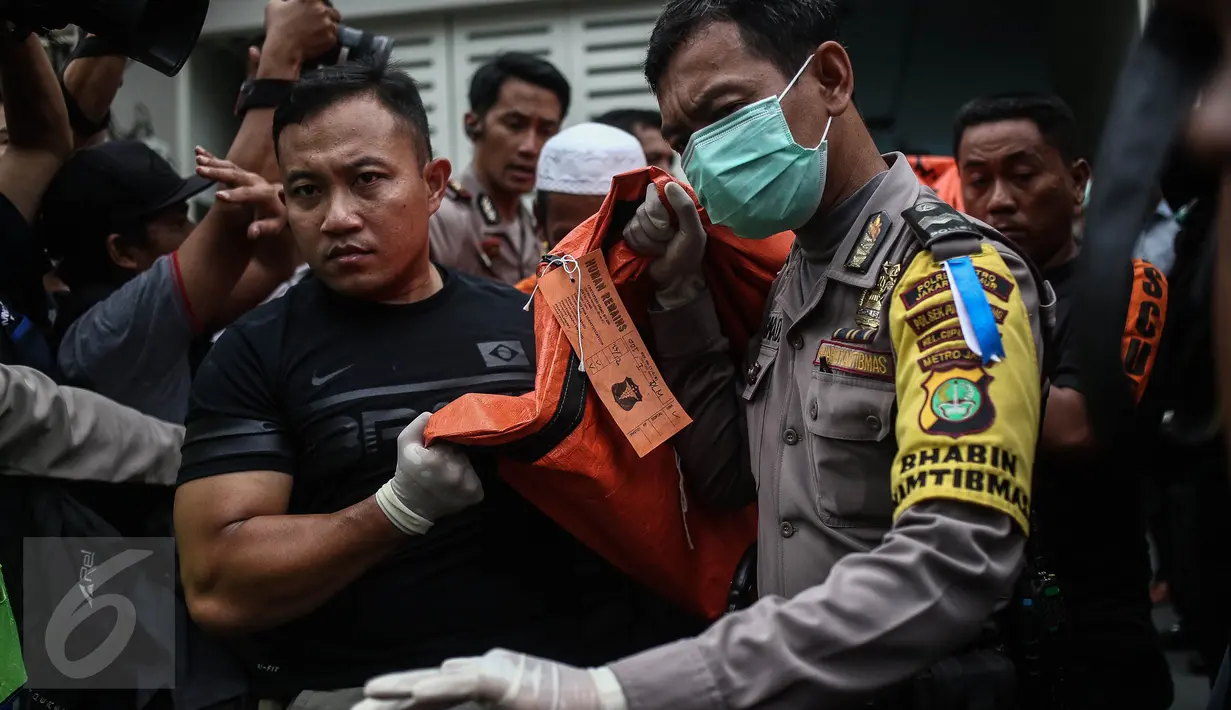 Petugas kepolisian membawa keluar jenazah pembunuhan di Jalan Pulomas Utara Nomor 7A, Kayuputih, Pulogadung, Jakarta, Selasa (27/12). Polisi tidak menemukan barang berharga yang hilang dalam peristiwa tersebut. (Liputan6.com/Faizal Fanani)