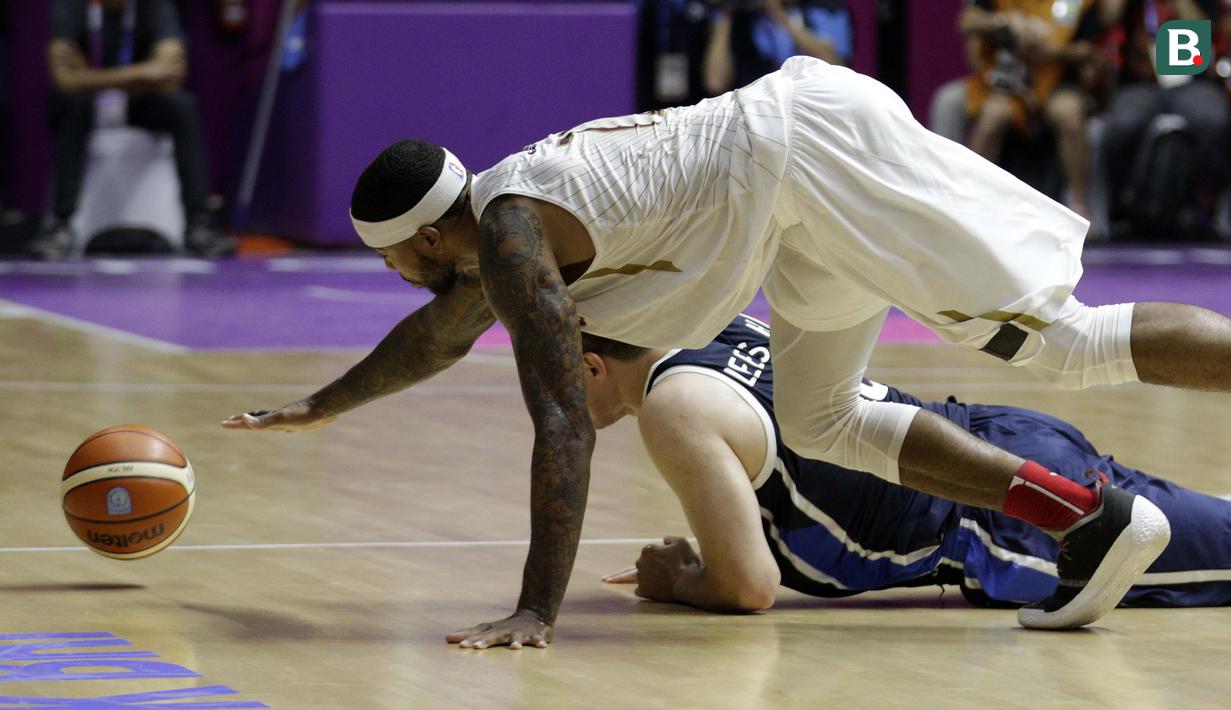 Pebasket Indonesia, Jamarr Andre Johnson, terjatuh saat berebut bola dengan pebasket Korea Selatan pada laga Asian Games 2018 di Hall Basket GBK, Selasa (14/8/2018). Indonesia takluk 65-104 dari Korsel. (Bola.com/Peksi Cahyo)