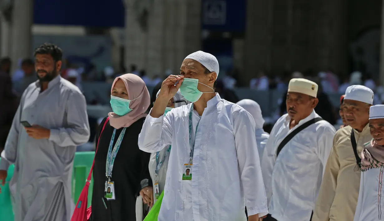 Umat Muslim mengenakan masker di Masjidil Haram, kota suci Makkah, Kamis (27/2/2020). Suasana Masjidil Haram berjalan sebagaimana biasanya pascapengumuman Pemerintah Arab Saudi melarang sementara jemaah umrah ke Tanah Suci terkait pencegahan penyebaran virus korona. (Abdulghani BASHEER/AFP)