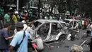 Warga melihat sisa mobil yang dibakar massa ketika aksi unjuk rasa menuntut pengusutan kasus penabrakan pengemudi ojek online di sekitar Markas Komando Korps Brigade Mobil (Brimob) Polda Metro Jaya, kawasan Kwitang, Pasar Senen, Jakarta, Jumat (29/8/2025). (merdeka.com/Arie Basuki)
