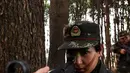 Tentara wanita China melakukan simualisi perang di tengah hutan saat melakukan latihan militer jelang Hari Perempuan Internasional di Hefei, China (6/4). (AFP)