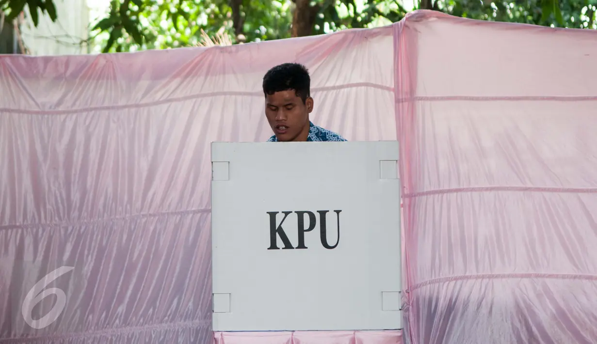 Seorang pria penyandang disabilitas menyobols dibilik suara saat menggunakan hak pilihya dalam Pilkada Putaran kedua di TPS 07 Kelurahan Cawang, Jakarta, Rabu (19/4). (Liputan6.com/Gempur M. Surya)