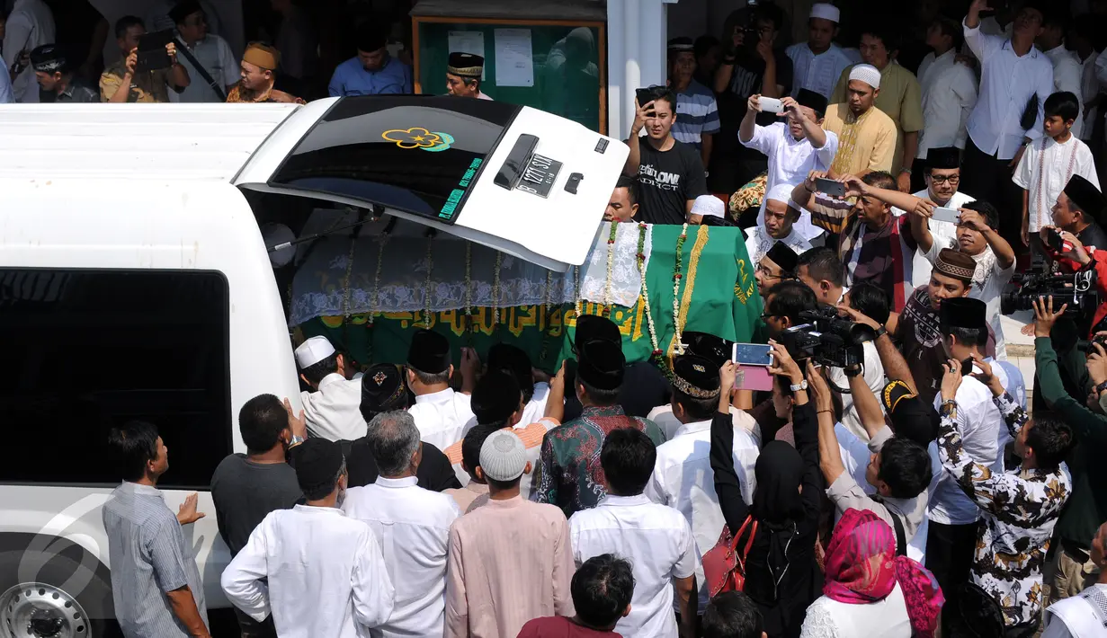 Sejumlah pelayat bersiap memasukkan jenazah Ketua KPU Husni Kamil Manik ke dalam mobil jenazah usai disalatkan di Kompleks KPU, Jakarta, Jumat (8/7). Husni Kamil Manik wafat diusia 40 tahun pada Kamis malam (7/7). (Liputan6.com/Helmi Fithriansyah)