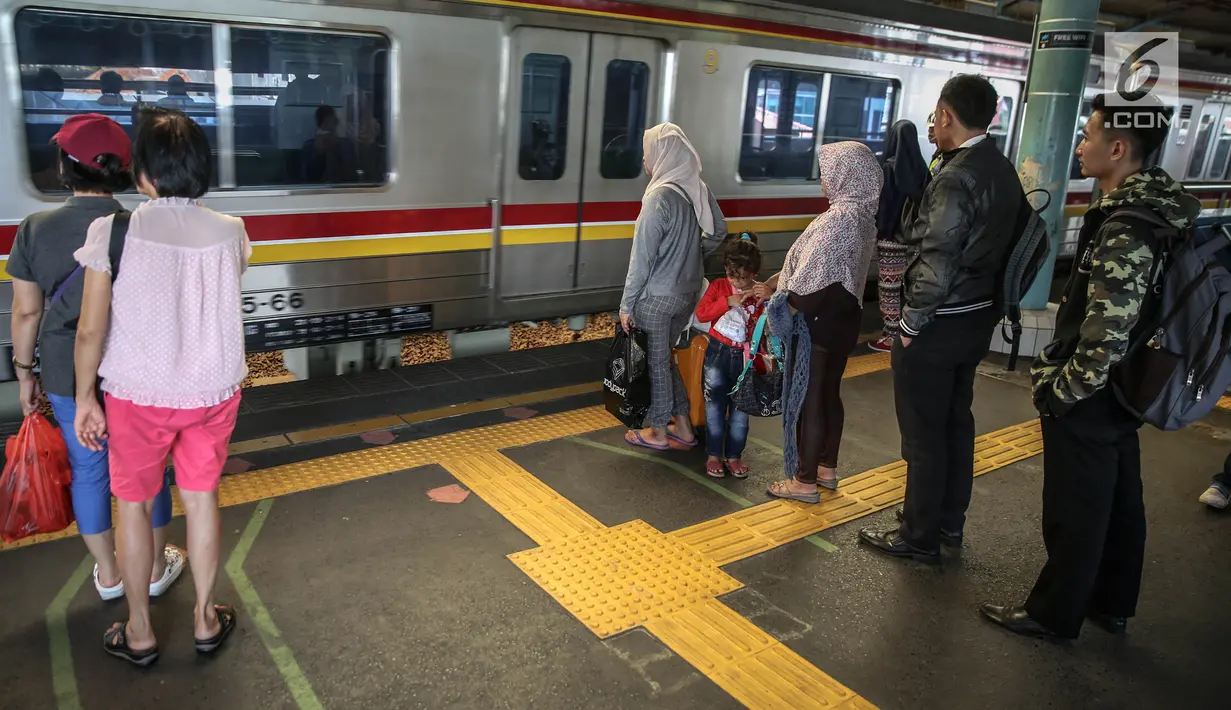 Penumpang berdiri di garis antrean penumpang di Stasiun Juanda, Jakarta, Kamis (10/8). Uji coba garis antrean penumpang juga guna mengurangi bahaya kecelakaan seperti penumpang terjatuh dan terdorong saat keluar masuk KRL. (Liputan6.com/Faizal Fanani)