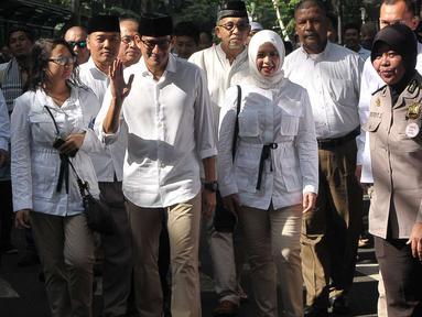 Calon Wakil Gubernur (Cawagub) DKI Jakarta, Sandiaga Uno bersama istri dan anaknya berjalan menuju lokasi untuk menggunakan hak pilihya dalam Pilkada Putaran kedua di TPS 01, Kebayoran Baru, Jakarta, Rabu (19/4). (Liputan6.com/Helmi Afandi)
