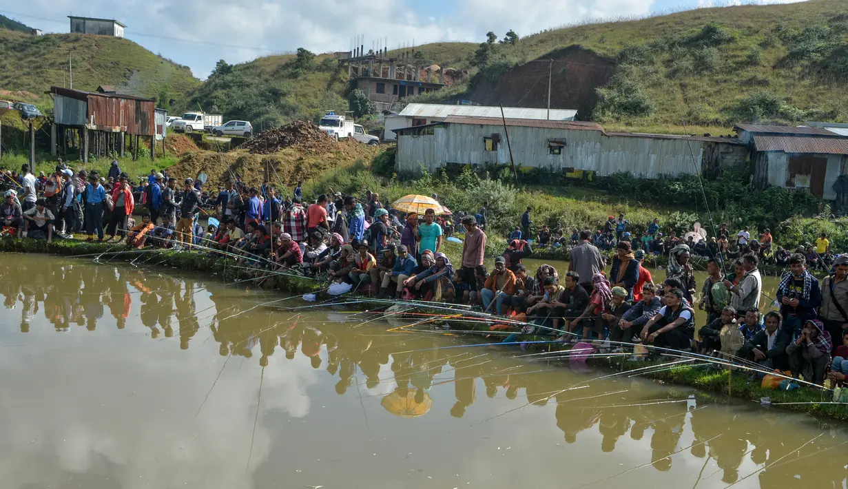 Para peserta pria mengikuti kompetisi memancing di sebuah kolam dekat desa Weilei di Negara Bagian Meghalaya, timur laut India, Sabtu (21/9/2019). Ratusan peserta berpartisipasi dalam kompetisi yang memperebutkan sejumlah hadia tersebut. (DIPTENDU DUTTA / AFP)