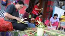 Sejumlah ibu serati banten mempersiapkan Gebogan yang akan digunakan dalam upacara Mecaru dalam menyambut perayaan hari Raya Nyepi dan Tahun baru Saka 1941 di Pura Tribhuana Agung Sukmajaya Depok, Jawa Barat, Selasa (5/3). (Liputan6.com/Herman Zakharia)