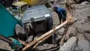 Banjir lahar dingin ini dipicu oleh hujan deras di wilayah hulu Merapi sejak siang hari, yang kemudian menghantam area penambangan pasir. Tampak dalam foto, warga berusaha mengambil bagian-bagian truk yang terkubur di pasir setelah longsor lumpur akibat hujan dari Gunung Merapi di Sungai Senowo, Magelang, Jawa Tengah pada Rabu 4 Maret 2026. (Devi Rahman/AFP)
