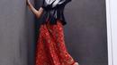 Nadine Chandrawinata memberi ide tampilan modern chic dengan top hitam dan kain atau rok batik asimetris warna bold yang mengelevansi tampilan (Instagram @nadinelist)