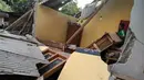 Seorang pria berdiri di antara reruntuhan rumah yang rusak akibat gempa di Lombok, NTB, Minggu (29/7). Data sementara BPBD Provinsi NTB mencatat, gempa bumi tektonik 6.4 SR itu mengakibatkan 10 orang meninggal dunia (HO/NTB DISASTER MITIGATION AGENCY/AFP)