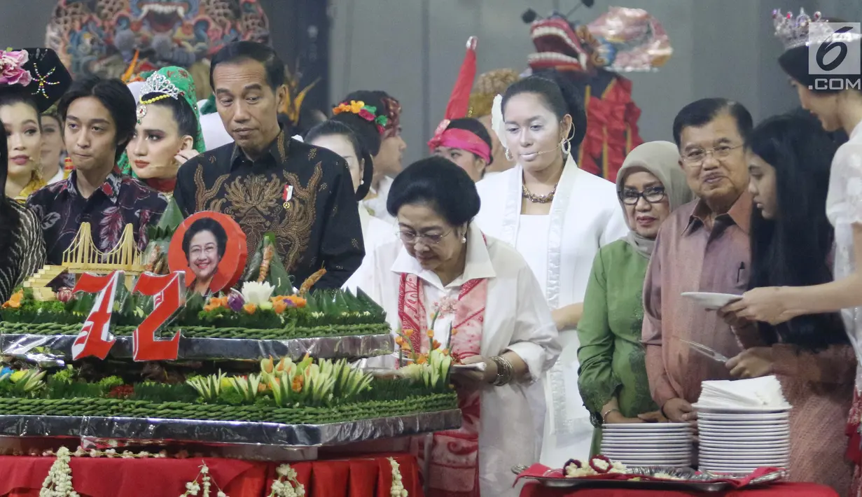 Ketum PDIP Megawati Soekarnoputri memotong tumpeng pada HUT ke-72 didampingi Presiden Joko Widodo serta Wapres Jusuf Kalla di Grand Sahid Jakarta, Rabu (23/1). Sejumlah menteri Kabinet Gotong Royong hadir dalam acara tersebut. (Liputan6.com/Angga Yuniar)