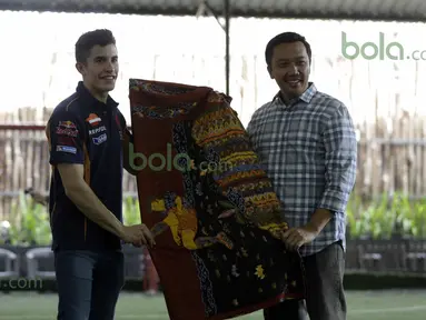 Marc Marquez menerima kain batik dari Menteri Pemuda dan Olah Raga Imam Nahrowi di Lapangan Futsal Kuningan Village, Jakarta, Sabtu (13/2/2016). (Bola.com/Nicklas Hanoatubun)
