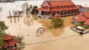 Otoritas setempat mengatakan, hujan deras yang disertai angin kencang menyebabkan sejumlah rumah rusak, aliran listrik terputus, serta jalanan banjir. (Phan Duy/AFP)
