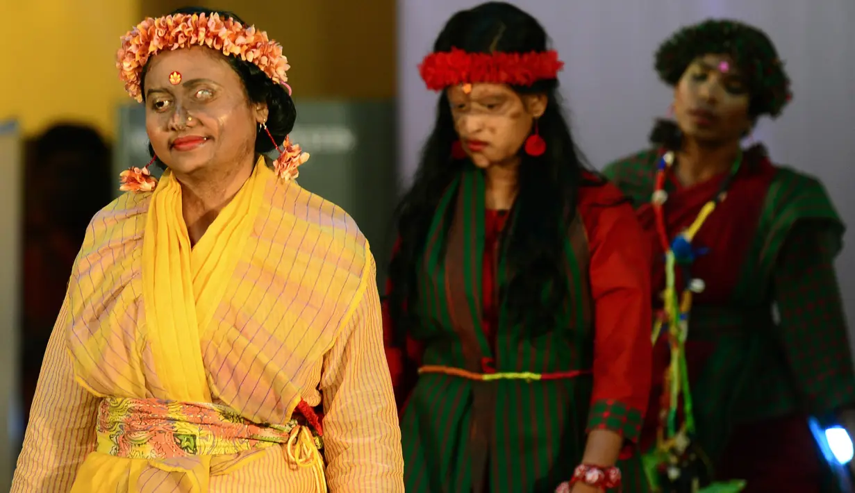 Para wanita korban serangan cairan asam berjalan di atas catwalk pada pagelaran busana "Beauty Redefined" di Dhaka, Bangladesh, 7 Maret 2017. Siraman air keras ini membuat kulit wajah para model dan beberapa bagian lainnya terbakar dan melepuh. (STR/AFP)