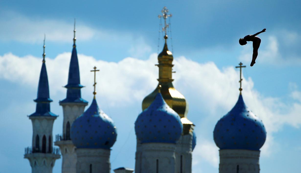 Peloncat indah Inggris, Gary Hunt, beraksi di nomor High Diving 27m putra dalam Kejuaraan Dunia Akuatik 2015 di Kazan, Rusia. (3/8/2015). Bangunan di latar gambar adalah Masjid Kul Sharif (kiri) dan Katedral Annunciation. (Reuters/Hannibal Hanschke).