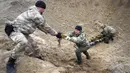 Pencari ranjau dari Kementerian Dalam Negeri Ukraina menyiapkan bahan peledak pada sebuah lubang untuk meledakkannya dekat ladang ranjau setelah pertempuran baru-baru ini di Desa Moshchun, dekat Kiev, Ukraina, 19 April 2022. (AP Photo/Efrem Lukatsky)