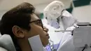 Robot Cira 03 melakukan tes PCR terhadap seorang pria di sebuah rumah sakit di Kota Tanta, Provinsi Gharbiya, Mesir, 3 Desember 2020. Mahmoud el-Komy mengembangkan robot tersebut hingga belum lama ini berhasil membuat versi prototipenya yang terbaru. (Xinhua/Ahmed Gomaa)